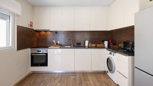 Eine moderne Küche mit Einbauofen, Waschmaschine und Spüle.