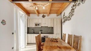 Une cuisine moderne avec des meubles en bois, un îlot central et un coin repas doté de chaises en bois.