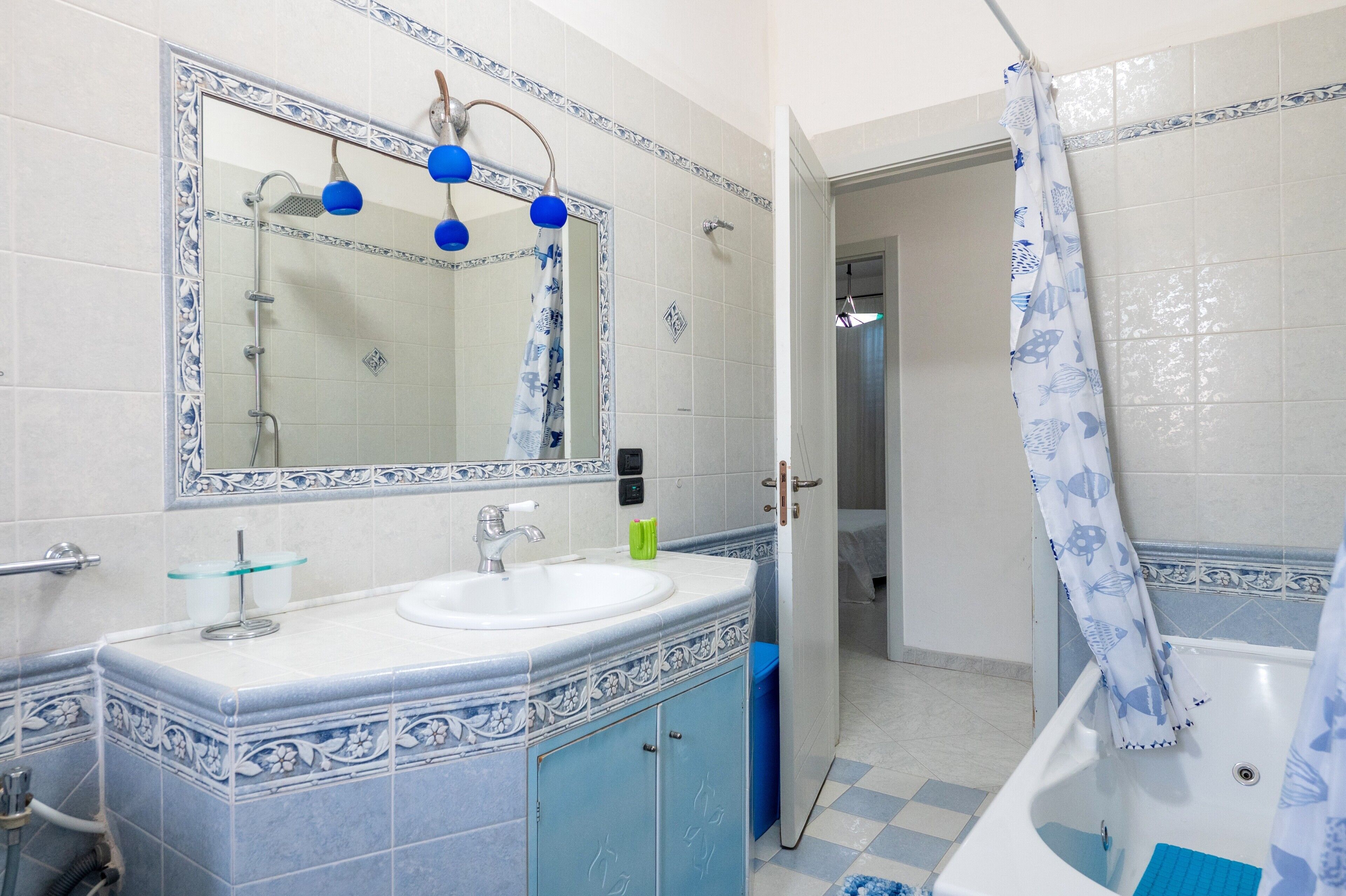 Une salle de bain équipée d’un lavabo, d’un miroir, d’une douche et d’une baignoire.