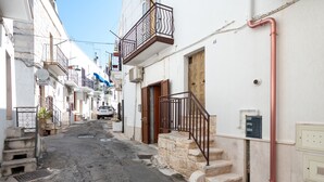 A narrow street with stone steps leading to a building with a wooden door and a metal railing. - Studio Apartment 'Casa Roby' with Wi-Fi and Air Conditioning (Ceglie Messapica)