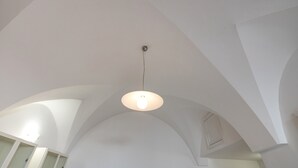 A room with a high arched ceiling and a hanging light fixture. - Studio Apartment 'Casa Roby' with Wi-Fi and Air Conditioning (Ceglie Messapica)