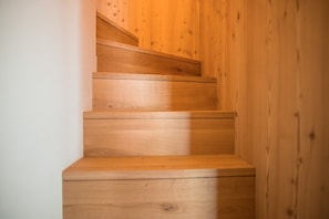 Un escalier en bois, doté d’une rampe, menant à l’étage supérieur.