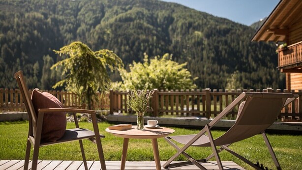 A deck with two chairs and a table, overlooking a forested mountain. - Sunnseit Luxury Apartment 3 – Private Garden & Sauna, Lake View (Ultimo)