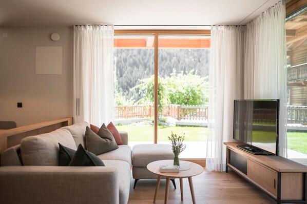 A modern living room with a sofa, a coffee table, and a television.