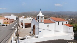 A white building with a bell tower, a street in front, and mountains in the background. - Holiday Apartment "Verode" with Sea View, Shared Terrace & Wi-Fi (Arico)