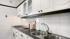 A kitchen with white cabinets, a stainless steel sink, a granite countertop, and a gas stove. - Holiday Apartment "Los Morales" with Sea View, Shared Terrace & Wi-Fi (Arico)