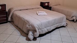 Ein Schlafzimmer mit zwei Betten, einem Nachttisch und einer Kommode.