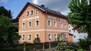 Un immeuble à plusieurs étages, doté d’une façade symétrique, de nombreuses fenêtres et d’une entrée bien visible.