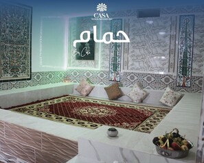 A hotel room with a large, ornate carpet, a bathtub, and a bowl of fruit on the side. - Casa Hotel & Hammam Spa (Fernana)