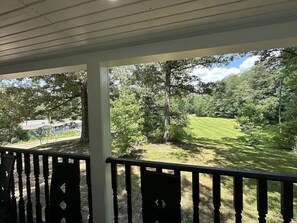A covered porch with a view of a grassy area and trees. - Modern 2 bed Home 10 mins from Dtown Gainesville (Gainesville)