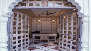 An entrance with a checkered floor, a table with chairs, and a ceiling fan. - Dev Mahal - A Boutique Heritage Hotel (Jaipur)