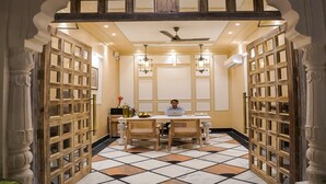 A room with a central table, chairs, a ceiling fan, and a patterned floor. - Dev Mahal - A Boutique Heritage Hotel (Jaipur)