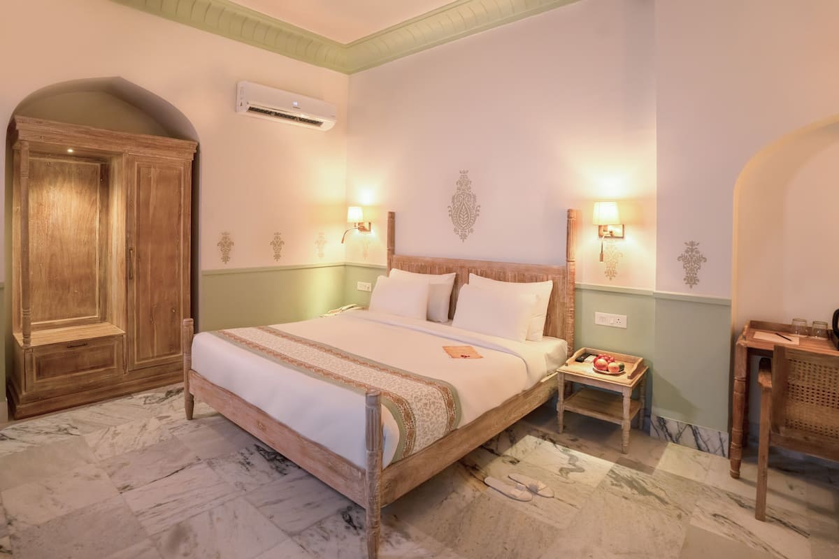 A bedroom with a wooden bed, a nightstand with a tray of fruit, and a wardrobe.