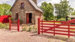 A stone farmhouse with a red gate and a red fence. - Charming stone house with garden, ideal for couple (Gavray-sur-Sienne)