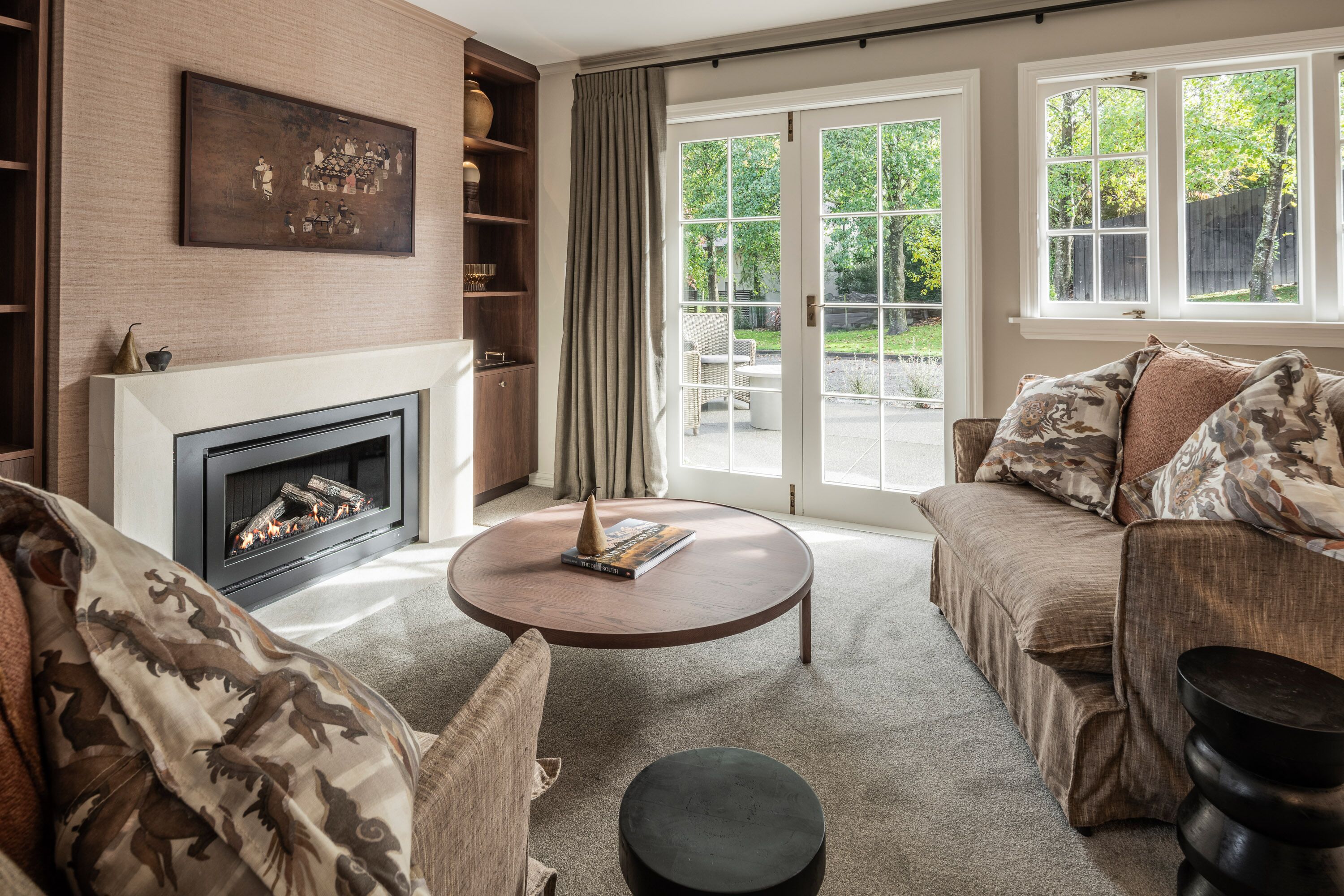 Ein Wohnzimmer mit Kamin, einer Couch, einem Couchtisch und einem Bücherregal.