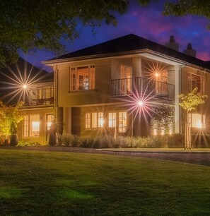 A two-story house with a balcony on the second floor, a well-maintained lawn, and a clear night sky. - Oakview (Hanmer Springs)