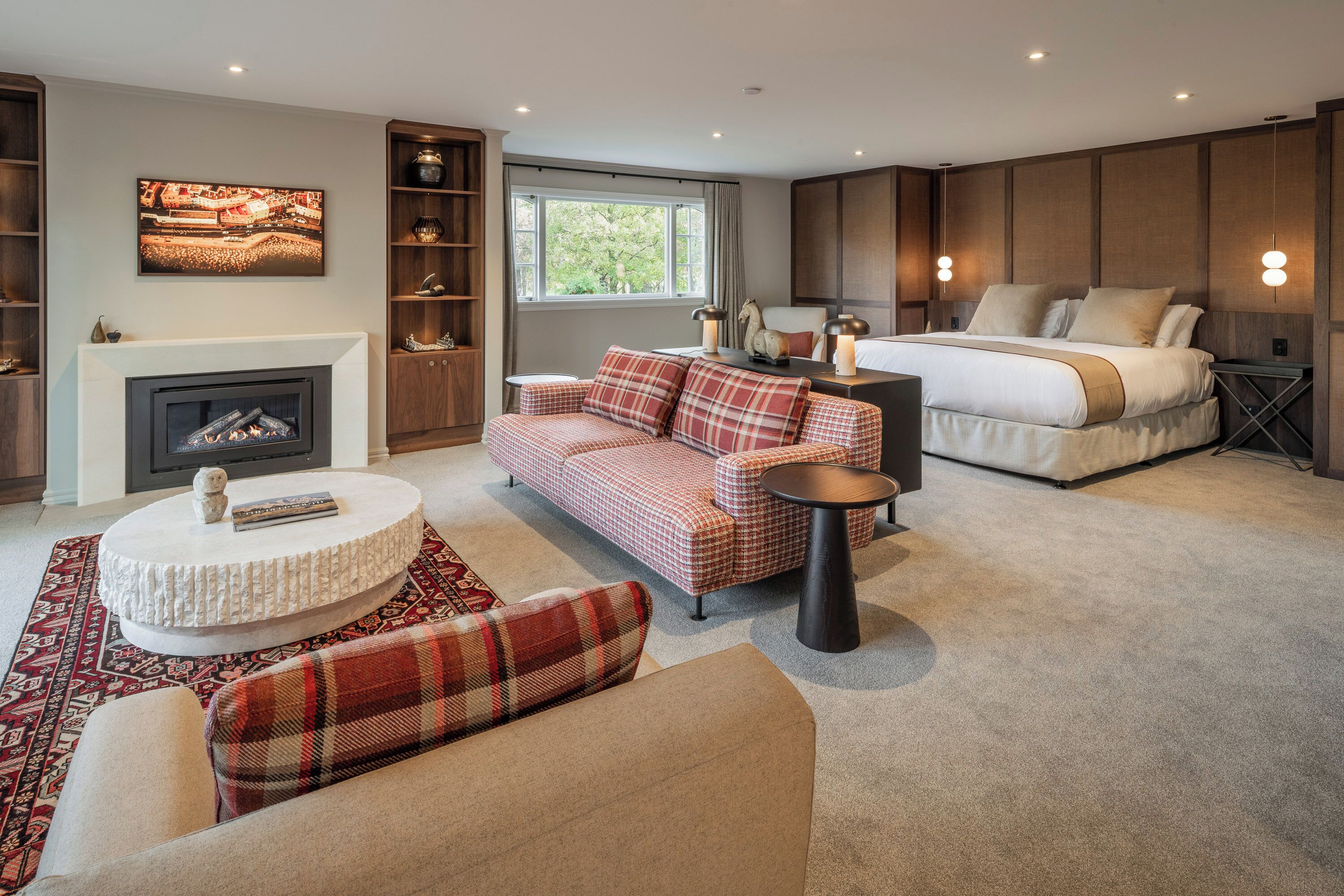 A modern living room with a fireplace, a sofa, a bed, and a coffee table.