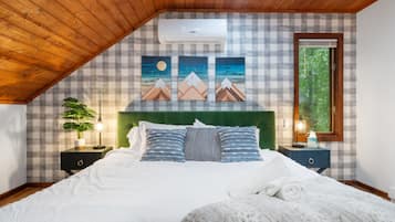 A bedroom with a checkered wall, a green headboard, and a bed with white bedding.
