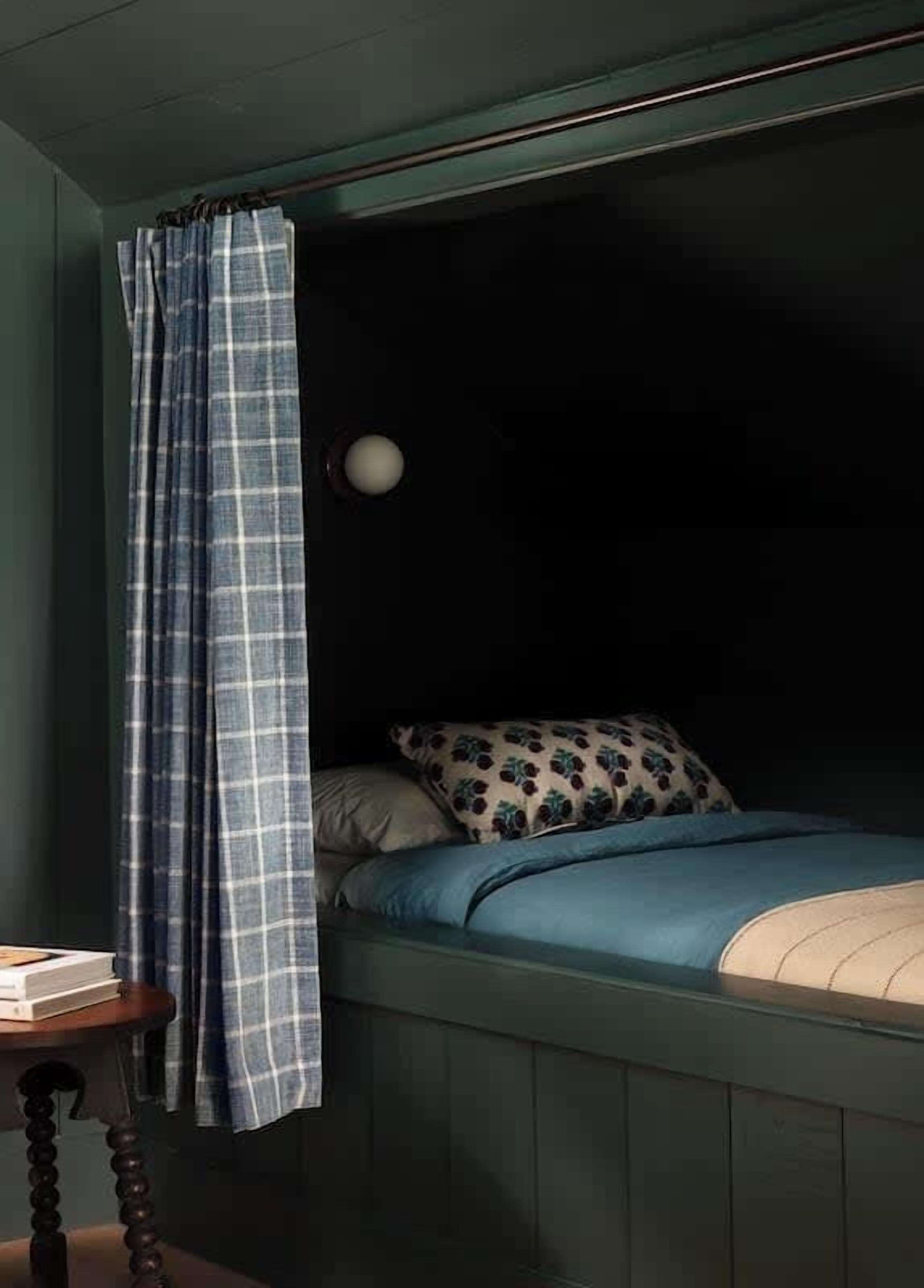 A small, cozy room with a bed, a pillow, and a bedside table.