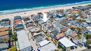 Un pueblo costero con playa, edificios residenciales y un muelle.
