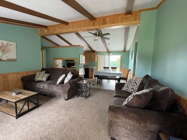 A cozy living room with two sofas, a coffee table, and a dining area with a table and chairs.