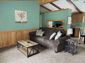 A living room with a sofa, coffee table, and lamp.