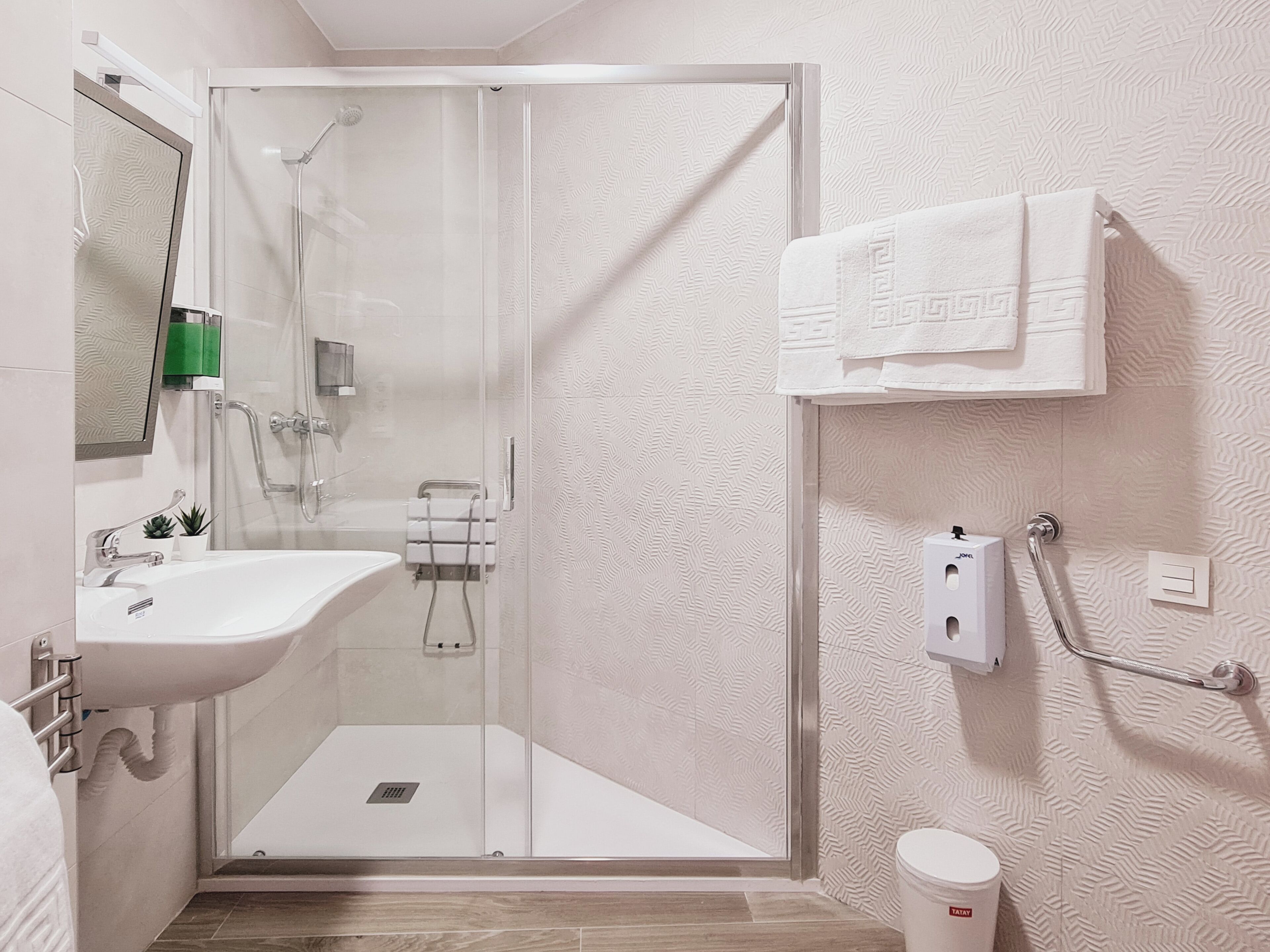 Un baño moderno con ducha de vidrio, un lavabo y un inodoro.