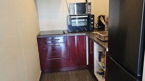 A compact kitchen with a microwave, toaster, and refrigerator. - Appartement Cosy 4 Personnes (Toulon)
