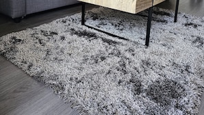 A modern living room with a grey sofa, a wooden coffee table, and a black and white rug. - Appartement Cosy 4 Personnes (Toulon)