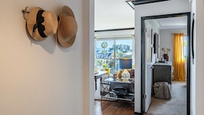 A hallway leading to a dining area with a view of palm trees and mountains.
