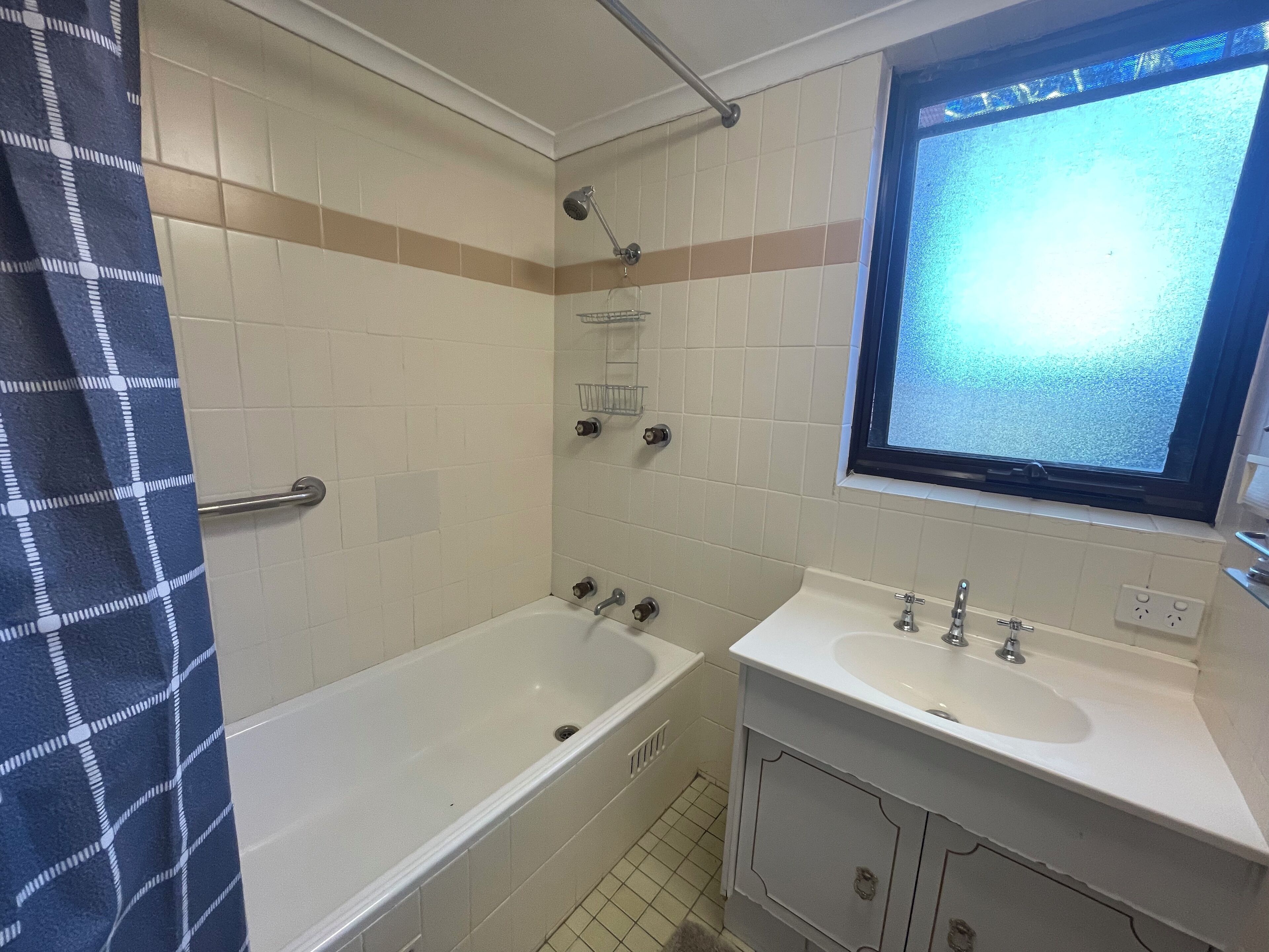 A bathroom with a bathtub, a sink, and a window.
