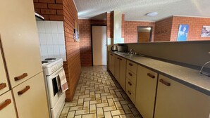 Una cocina con salpicadero de azulejos, estufa y encimera con lavabo.
