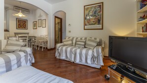 A living room with a sofa, TV, and a bookshelf. - Un minuto dal mare (Bogliasco)