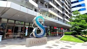 Un hotel moderno con un llamativo logo en forma de 'S', varios balcones y fachada de vidrio.