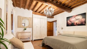 A bedroom with a bed, a dresser, a mirror, and a chandelier. - Apartment for 2/3 guests with panoramic patio, pool and Wi-Fi (Toscana)
