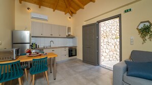A compact kitchen with a dining area, a built-in oven, and a refrigerator. - Kipseli Villa, Overlooking Vassiliki bay (Lefkada)