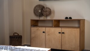 A wooden cabinet with two doors and a shelf, a wicker basket, and a pair of black headphones on top. - Kipseli Villa, Overlooking Vassiliki bay (Lefkada)