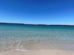 A beach with clear turquoise water and a sandy shore. - The Golden Retreat @ Hyams Beach - Pet Friendly, Linen & Wifi provided (Hyams Beach)