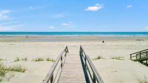 A wooden boardwalk leading to a sandy beach with a clear blue sky. - Oceanfront Mega Estate | Private Pool, Sleeps 25, Game Rooms & Decks (Isle of Palms)