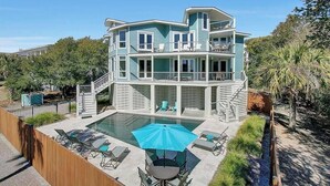 A two-story house with a pool, outdoor seating, and a balcony. - Second Star | Oceanview Coastal Showpiece with Private Pool (Isle of Palms)