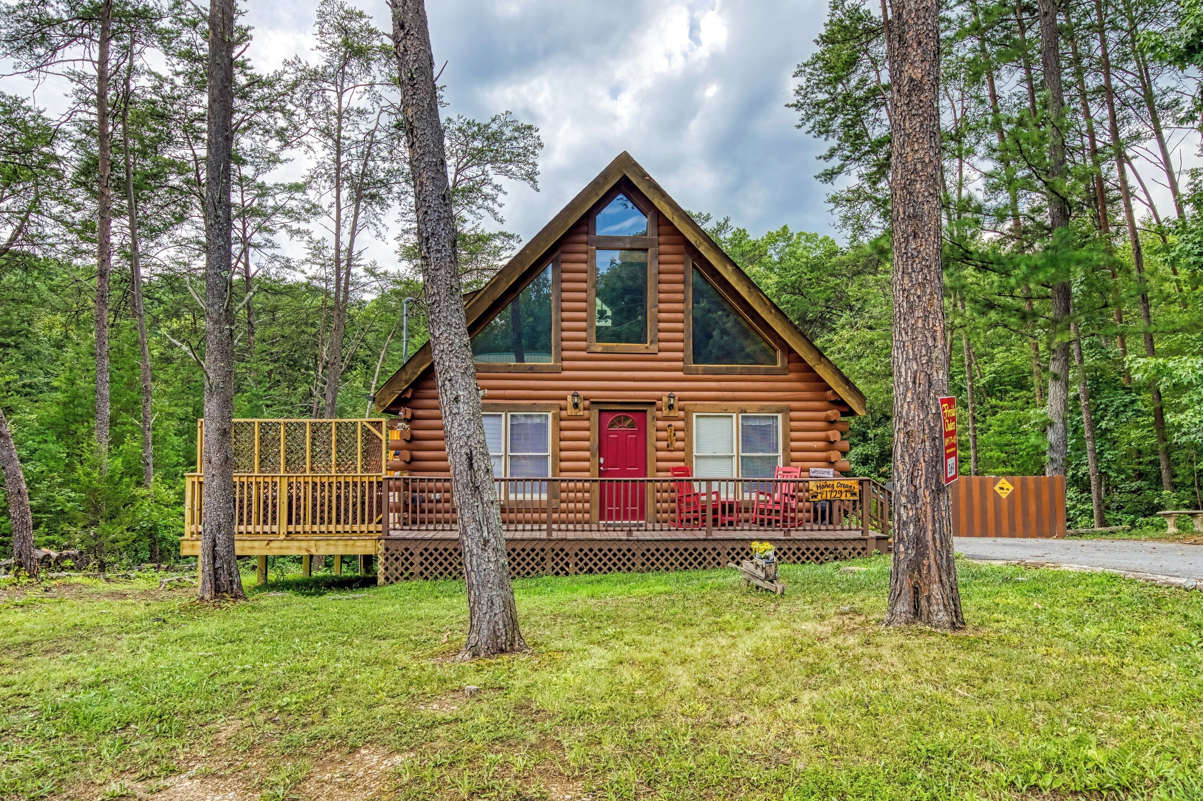 Eine Blockhütte mit roter Tür, großen Fenstern und einer Veranda.