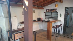 Une cuisine compacte avec un comptoir-bar en bois, un évier et un réfrigérateur.