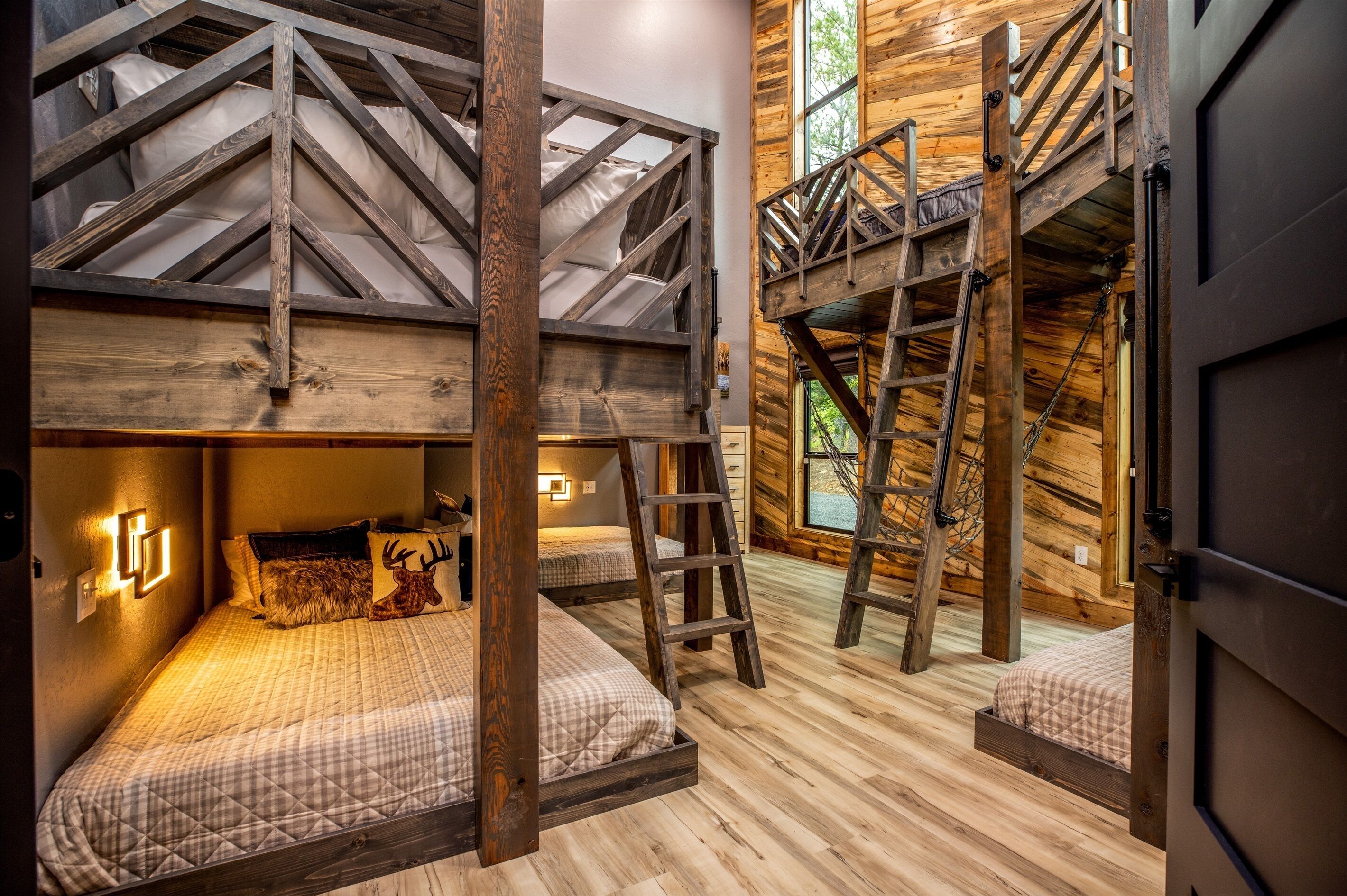 L’intérieur d’un chalet rustique, avec un lit en mezzanine, une échelle et un escalier.