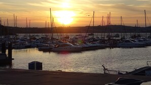 Un puerto deportivo con varias embarcaciones amarradas al atardecer.