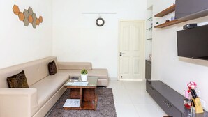 Un salon moderne avec un canapé, une table basse et un téléviseur.
