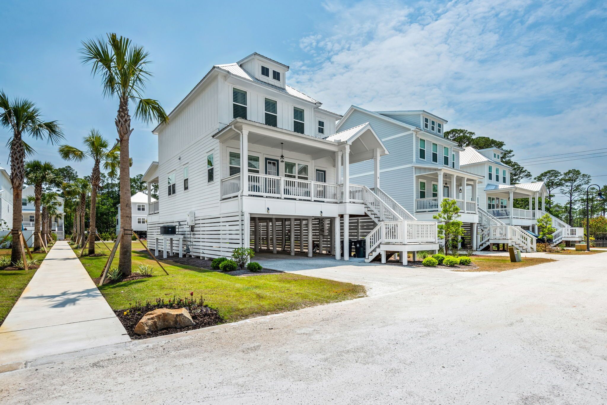 A large, two-story white building with a covered porch and multiple staircases.