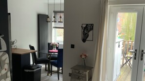 Un salon moderne comprenant un coin repas, une porte-fenêtre coulissante donnant sur l’extérieur et une vue sur le jardin arrière.