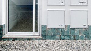 A white building with a glass door and numbered mailboxes labeled 'Luz', 'Aqua', '8', 'Correio', and 'EDP'. - Front Sea Apartment Albufeira (Albufeira)