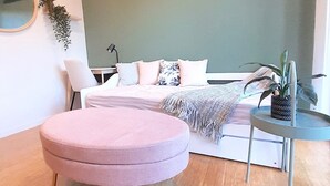 A modern bedroom with a bed, bedside table, and a round ottoman. - Stunning Family Retreat Perfect Location (melbourne)