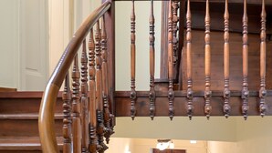 A wooden staircase with a spiral design leading to an upper floor.